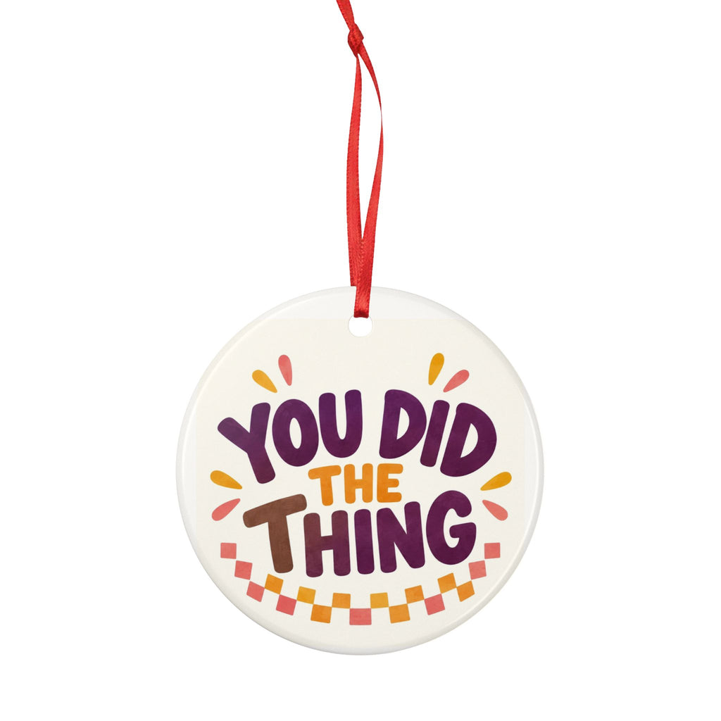 Round ceramic hanging ornament showing bold You Did the Thing lettering with confetti and a checker garland.