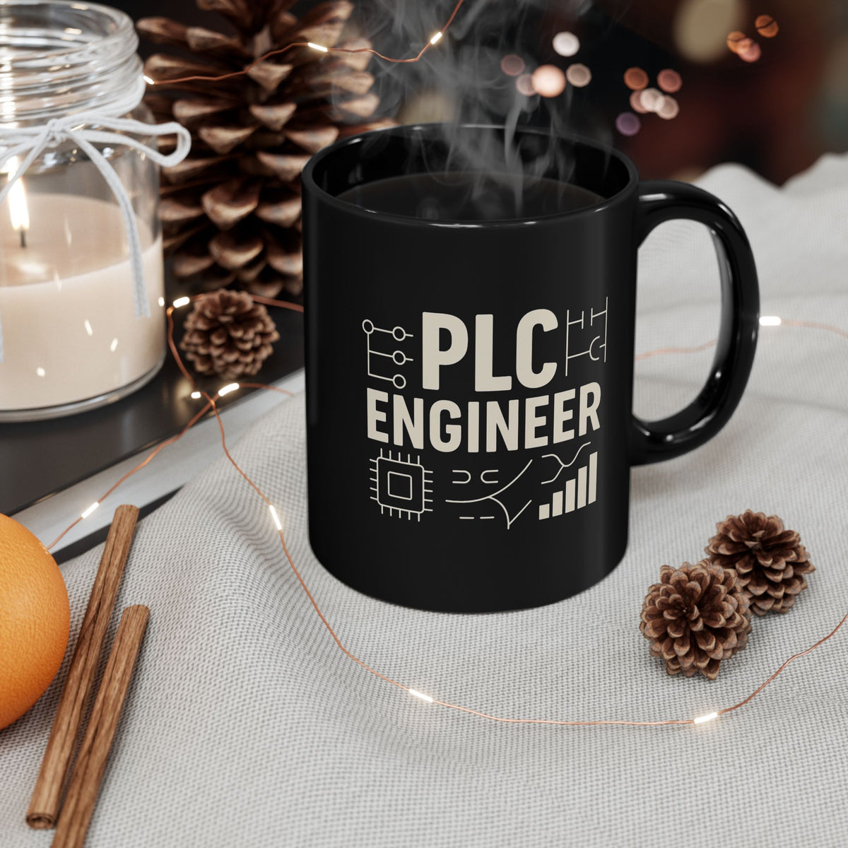 Steaming black PLC Engineer mug styled with pine cones and fairy lights