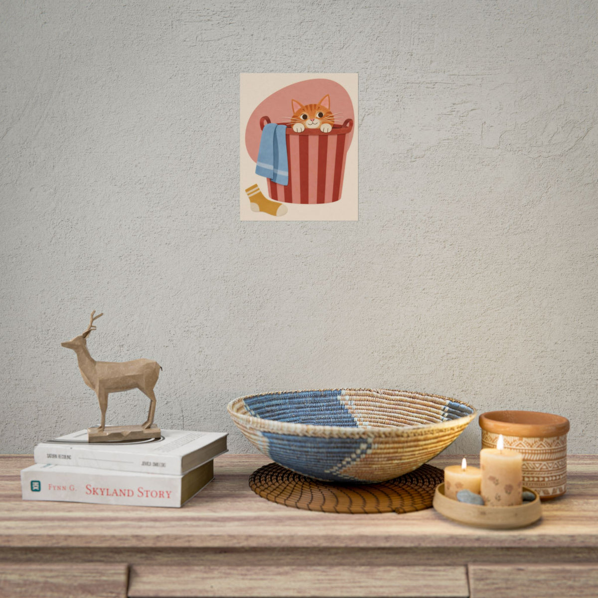 Laundry Day art print by Cozy Prints UK: ginger cat peeking from a striped laundry basket with a blue towel.