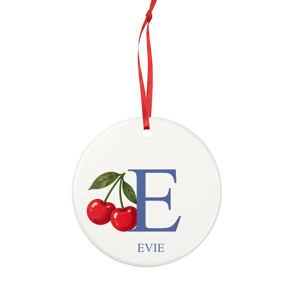 Round ceramic hanging ornament showing large blue sample initial E, two red cherries and the sample name Evie.