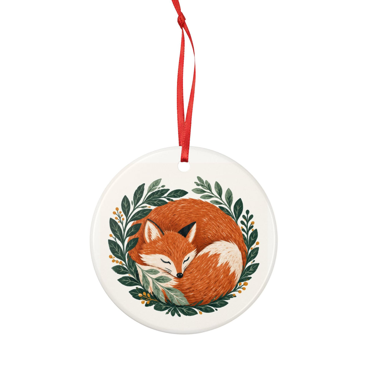 Round ceramic hanging ornament showing sleeping russet fox curled among green woodland leaves.