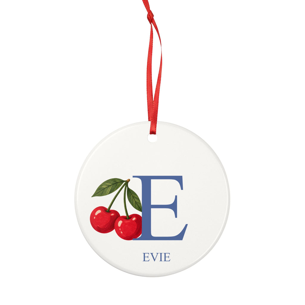 Round ceramic hanging ornament showing large blue sample initial E, two red cherries and the sample name Evie.