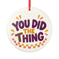 Round ceramic hanging ornament showing bold You Did the Thing lettering with confetti and a checker garland.