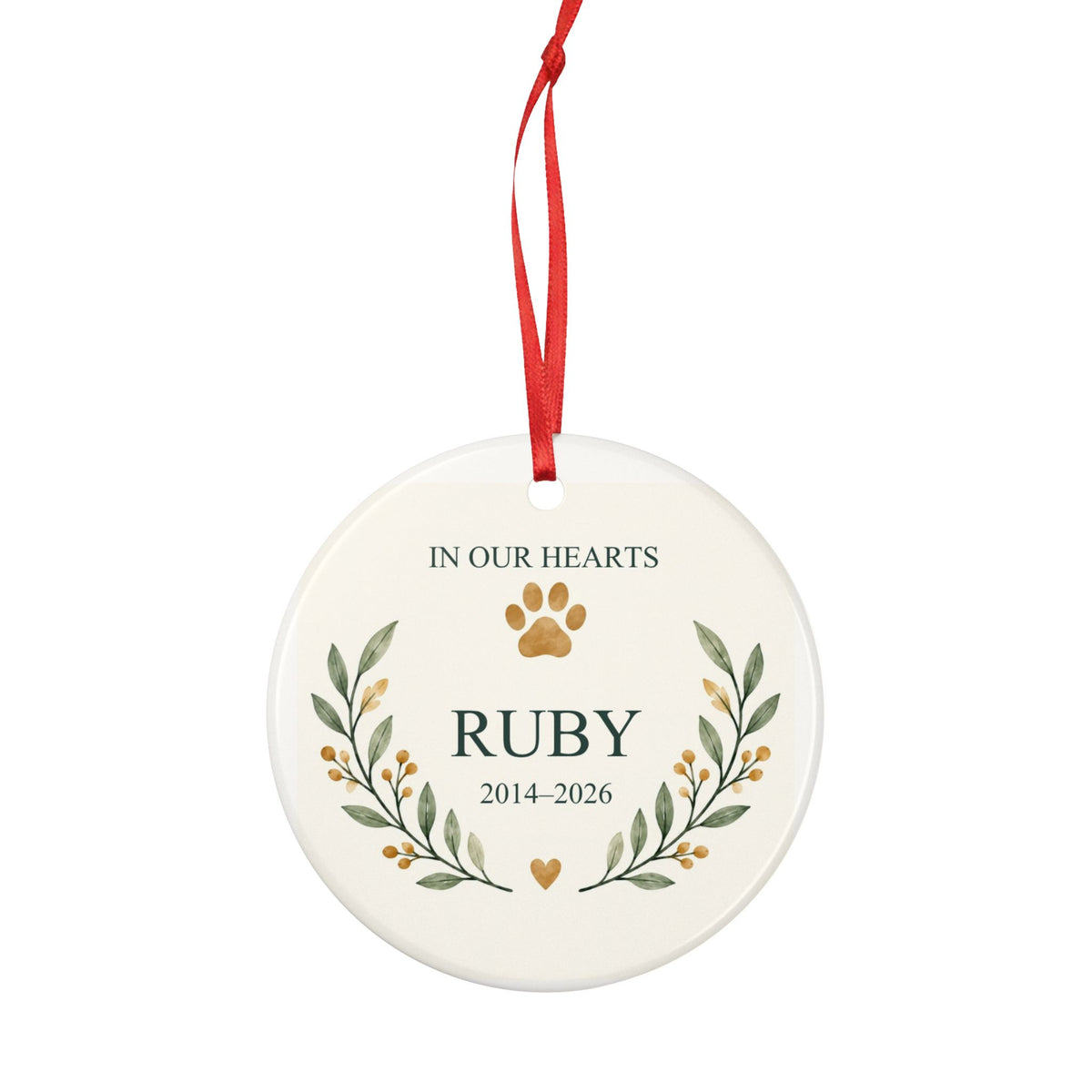 Round ceramic hanging ornament showing paw print and botanical branches around the sample name Ruby and sample years 2014–2026.