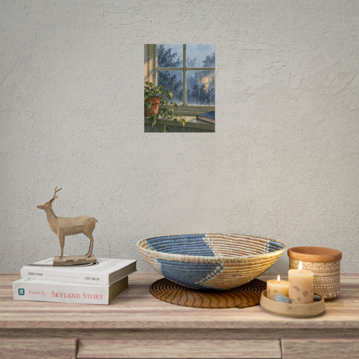 Rain at the Window art print by Cozy Prints UK, featuring rain-speckled glass, a leafy plant and a blue book in soft blue and sage tones.