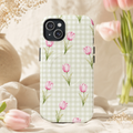 Pink Tulip Gingham phone case with pink flowers on sage checks, standing among tulips and cream fabric.
