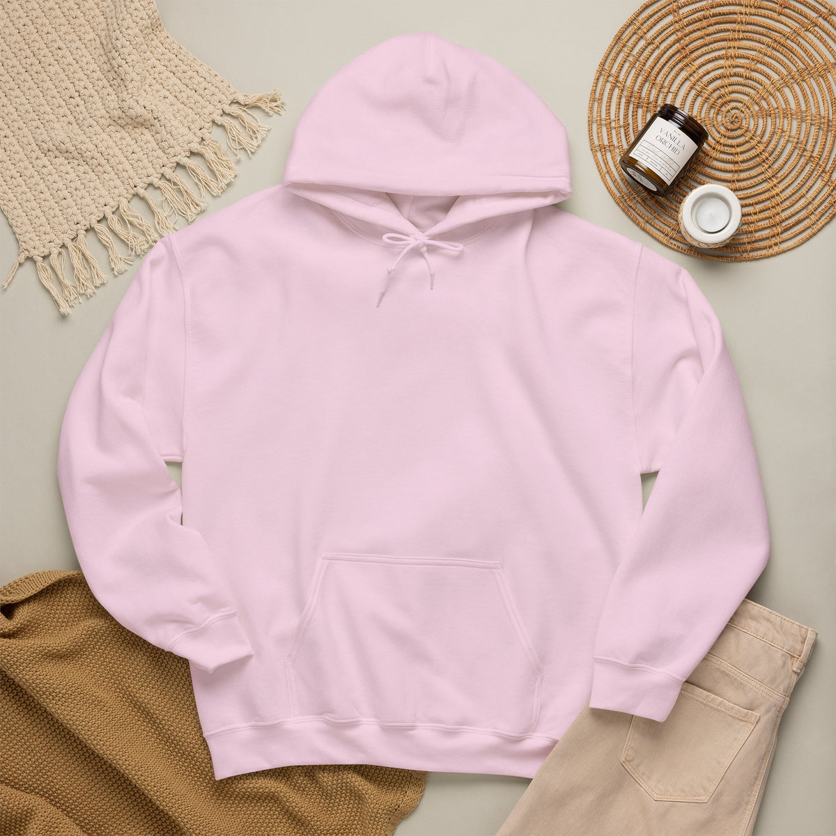 Light pink hoodie laid flat with neutral accessories