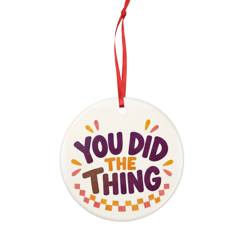 Round ceramic hanging ornament showing bold You Did the Thing lettering with confetti and a checker garland.