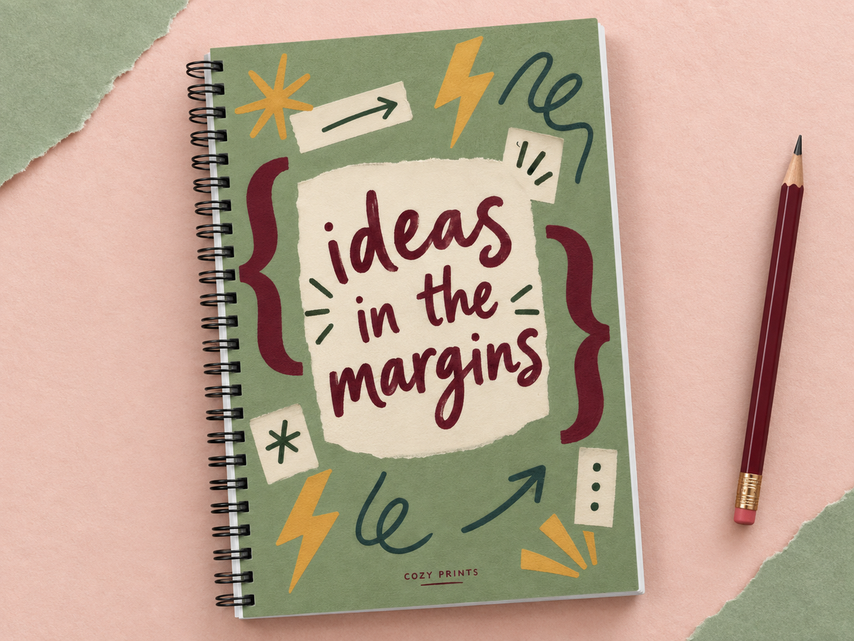 Ideas in the Margins A5 wirebound notebook with a sage doodle cover and burgundy lettering on a blush backdrop.