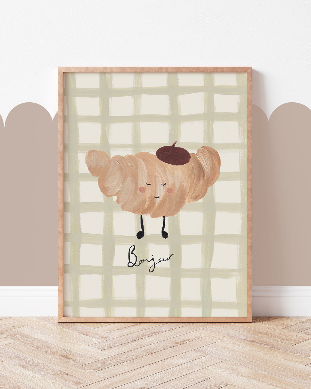 Croissant art print with a smiling beret-wearing pastry, Bonjour lettering and sage checks, displayed in a wooden frame.